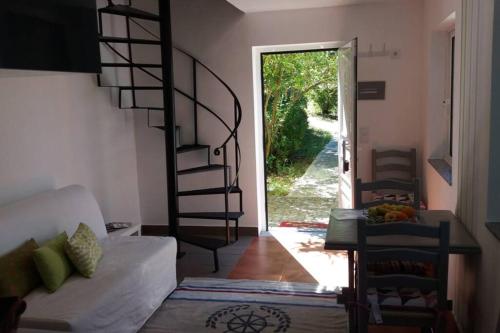 a living room with a spiral staircase leading to a door at casa das laranjeiras in Abragão