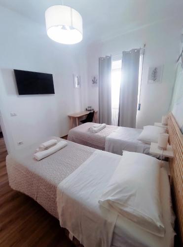 a hotel room with two beds and a television at Skyline #Downtown in Civitavecchia
