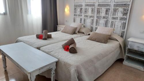 Dos camas con animales de peluche en un dormitorio en Tamarindo 27 pool front next to the dunes, free WIFI, en Corralejo