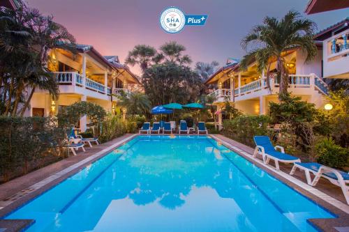 a swimming pool in front of a hotel at Ya Nui Resort - SHA EXTRA Plus in Rawai Beach