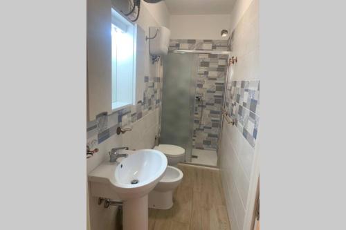 La salle de bains est pourvue d'un lavabo, de toilettes et d'une fenêtre. dans l'établissement Pizzo beach club 165G, à Pizzo