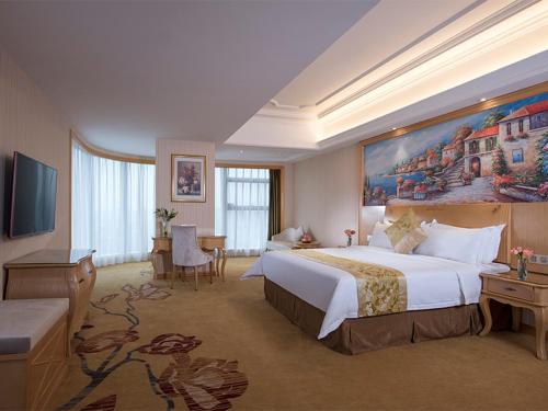 a hotel room with a large bed and a television at Vienna Hotel(Xiangtan Center Branch ) in Xiangtan