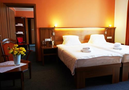 Una habitación de hotel con una cama con dos toallas. en Hotel Baltaci U Náhonu, en Zlín
