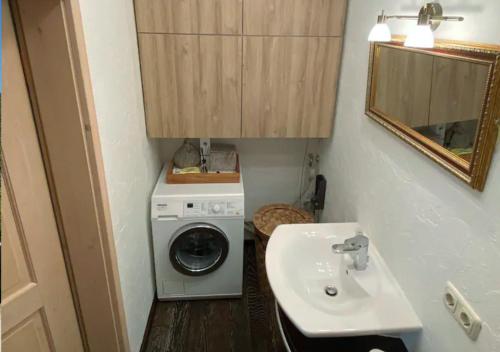 a bathroom with a washing machine and a sink at Sweet Alpen Home in Garmisch-Partenkirchen