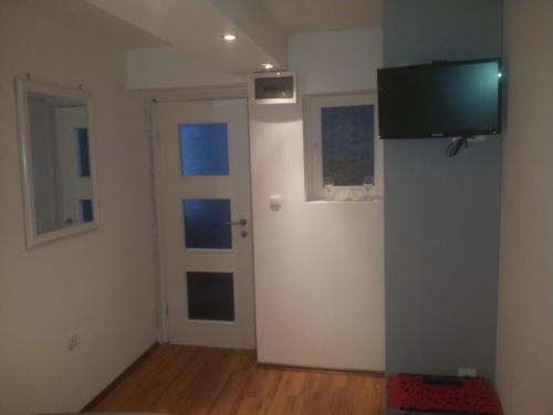 Zimmer mit einer Tür und einem TV an der Wand in der Unterkunft Rooms & Apartment Lasta in Split