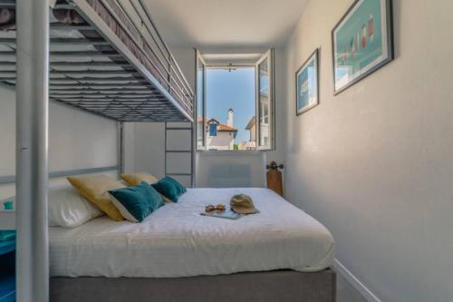 a bedroom with a bed with blue pillows at Appartement lumineux Côte des Basques in Biarritz