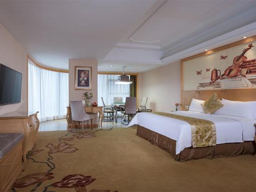 um quarto de hotel com uma cama grande e uma sala de estar em Vienna Hotel(Xiangtan Center Branch ) em Xiangtan