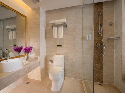 a bathroom with a toilet and a sink and a shower at Vienna Hotel Shunde Longjia Exhibition Center in Shunde