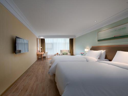 a hotel room with two beds and a television at Vienna Hotel(Xiamen Airport Xianmen Drum Whart) in Xiamen