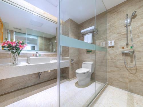 Guigang的住宿－維也納國際酒店廣西貴港荷城路店，浴室配有卫生间、盥洗盆和淋浴。