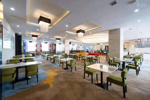 a dining room with tables and chairs and a cafeteria at Vienna Hotel Yinchuan Railway Station in Yinchuan