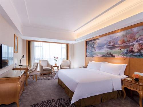 um quarto de hotel com uma cama grande e uma secretária em Vienna Hotel Shenzhen Shajing Shangnan em Bao'an