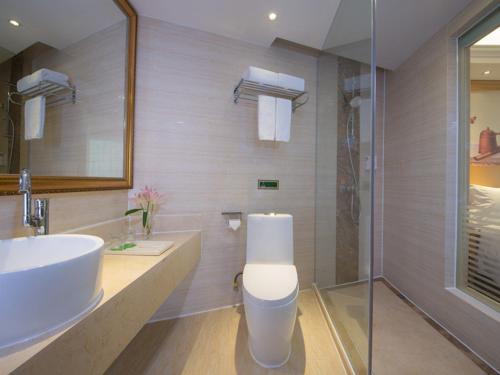 a bathroom with a white sink and a shower at Vienna Hotel Meizhou Xingning District Plaza in Libei
