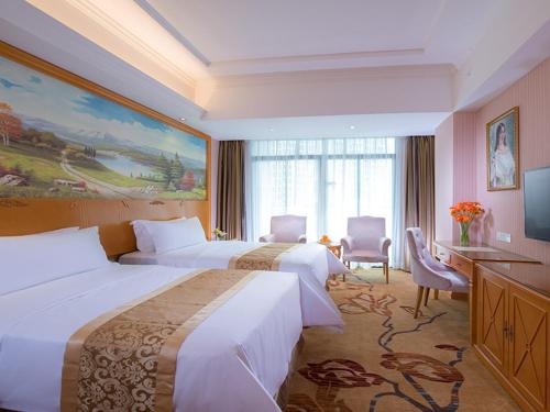 a hotel room with two beds and a television at Vienna Hotel Guangdong Huizhou Yuanzhou in Yuanzhou