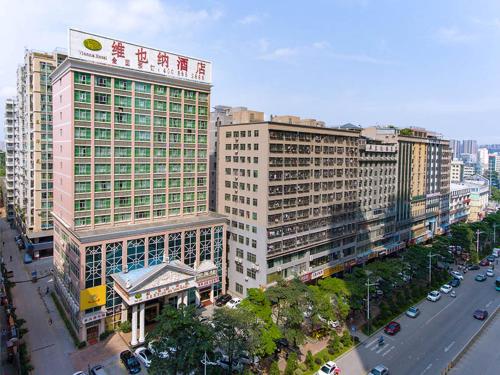 miasto z wysokimi budynkami i ulica z samochodami w obiekcie Vienna Hotel Shenzhen Yousong Branch w mieście Bao'an