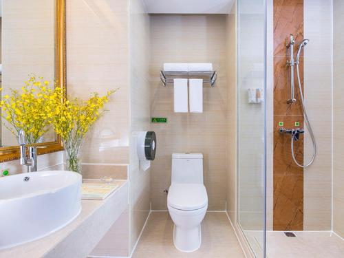 a bathroom with a toilet and a sink and a shower at Vienna Hotel Shenzhen Shiyan Shilong Community in Bao'an