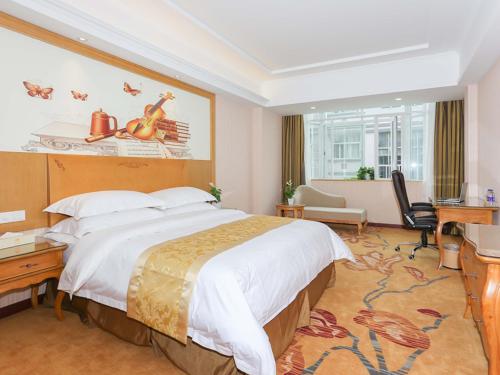 a hotel room with a large bed and a desk at Vienna Hotel Hangzhou Xiaoshan Airport in Kanshan