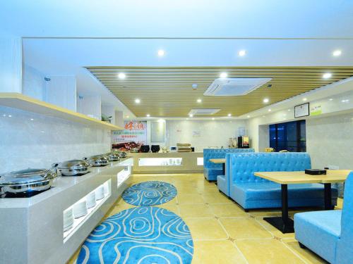 a large kitchen with blue chairs and a table at Vienna Zhihao Hotel Shenzhen Zhongying Street Shop in Shenzhen