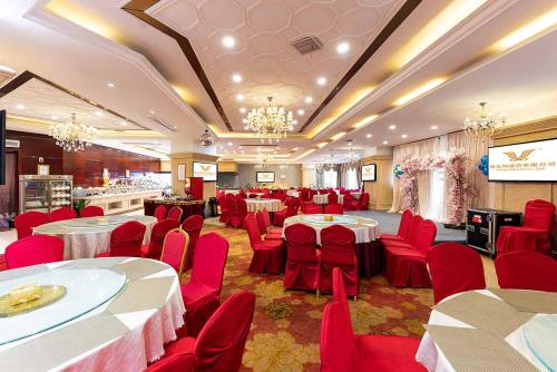 einen Bankettsaal mit roten Stühlen und Tischen in einem Zimmer in der Unterkunft Vienna Hotel Xinyu Kaiguang in Xinyu