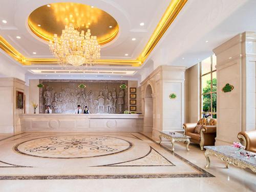 a large living room with a chandelier and a large rug at Vienna Hotel Shenzhen Unitown in Bao'an