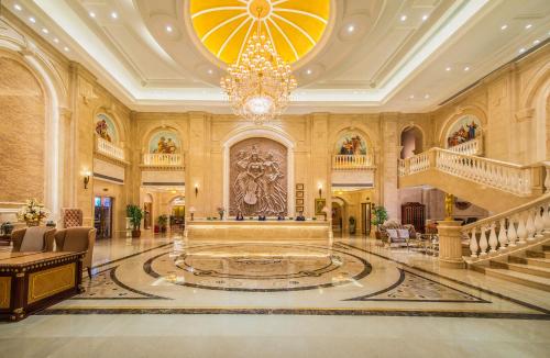 un grand hall avec un lustre et un escalier dans l'établissement Vienna International Hotel Fuzhou Cangshan Longfu, à Fuzhou