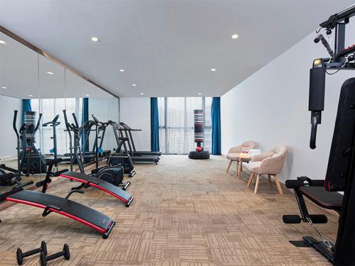 a gym with several treadmills and exercise bikes at Vienna International Hotel (Jiaxing Nanhu Hotel) in Jiaxing