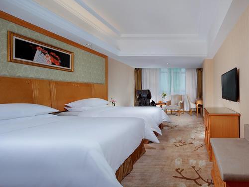 um quarto de hotel com quatro camas e uma televisão em Vienna Hotel Yueyang Zhanqian Road em Yueyang