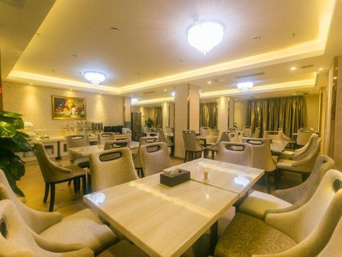 a restaurant with tables and chairs in a room at Vienna Hotel Sanya Yalong Bay Qianguqing in Sanya