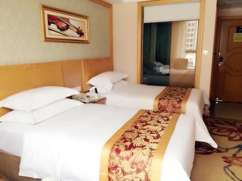 a hotel room with two beds and a window at Vienna Hotel Sanya Yalong Bay Qianguqing in Sanya