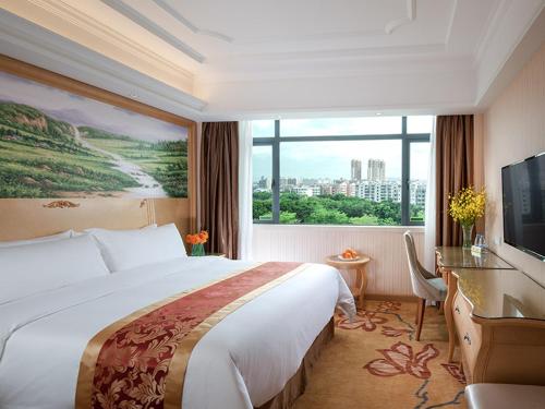 深圳的住宿－维也纳酒店深圳盐田港店，一间酒店客房,设有一张大床和一个大窗户