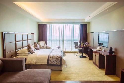 Vienna International Hotel Fuzhou Cangshan Longfu في فوتشو: غرفه فندقيه سرير وتلفزيون