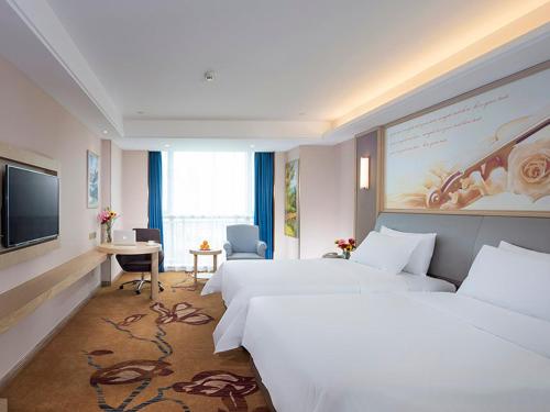 a hotel room with two beds and a flat screen tv at Vienna International Hotel (Jiaxing Nanhu Hotel) in Jiaxing