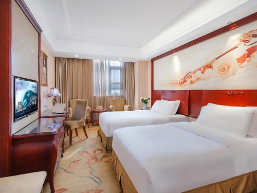 Vienna Hotel Jiangsu Shuyang Middle Renmin Road في Shuyang: غرفه فندقيه سريرين وتلفزيون