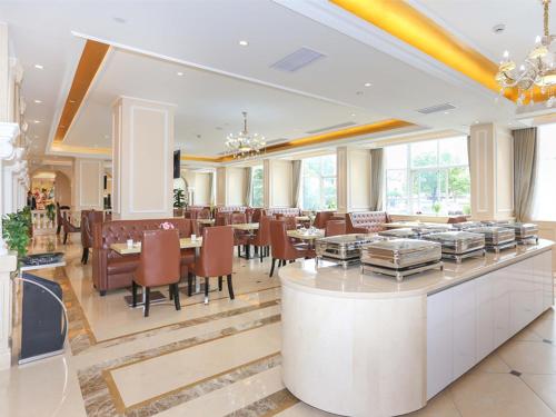 un ristorante con sala da pranzo con tavoli e sedie di Vienna Hotel Hangzhou Xiaoshan Airport a Kanshan