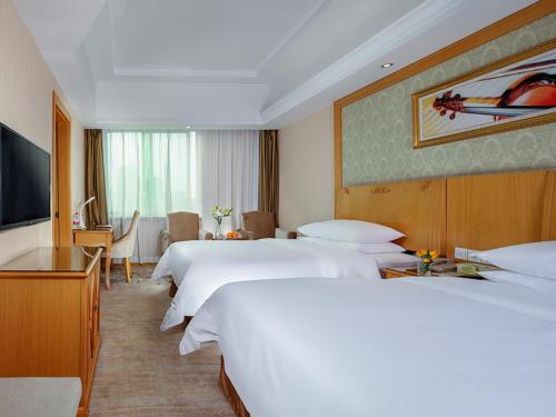 Tempat tidur dalam kamar di Vienna Hotel Yueyang Zhanqian Road