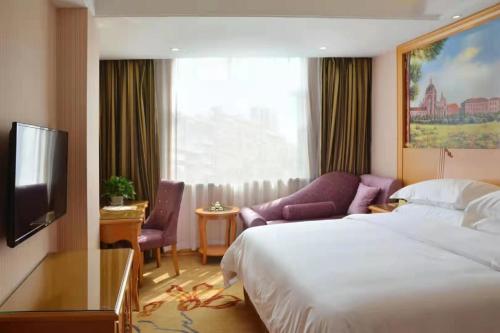 a hotel room with a bed and a tv at Vienna Hotel Anhui Mingzhu Square in Ershilipu