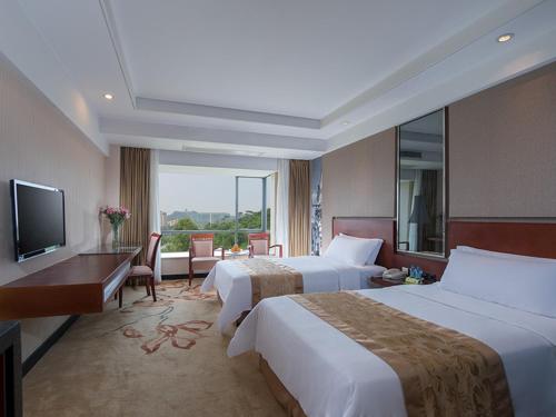 Habitación de hotel con 2 camas y TV en Vienna Hotel Dongguan Houjie Avenue, en Dongguan
