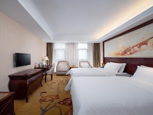 Vienna Hotel Chongqing Chuangyi Park في Shiping: غرفة فندقية بسريرين ومكتب