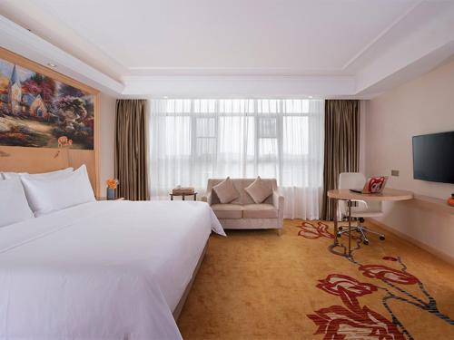 a hotel room with a large bed and a couch at Vienna Hotel (Jieyang Longwei) in Jieyang