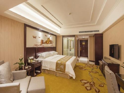 西安市にあるVienna Hotel Xi'an International Exihibition Centerのベッドルーム(大型ベッド1台付)、リビングルームが備わります。