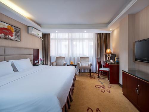 Cette chambre comprend un grand lit et un bureau. dans l'établissement Vienna Hotel Guangzhou Dekang Road, à Canton