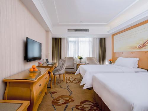 Habitación de hotel con 2 camas y TV en Vienna Hotel Jiujiang Railway Station, en Jiujiang