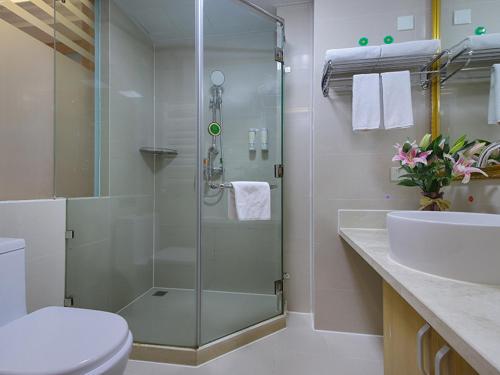 a bathroom with a shower and a toilet and a sink at Vienna Hotel Shandong Qingdao Chengyang in Xifu