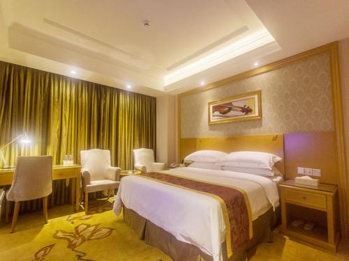 a hotel room with a large bed and a desk at Vienna Hotel Sanya Yalong Bay Qianguqing in Sanya