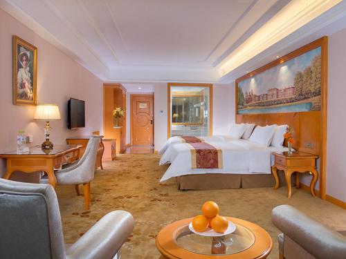 Venus Royal Hotel Guilin Airport في قويلين: غرفة نوم بسرير كبير وغرفة معيشة