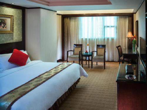a hotel room with a large bed and a desk at Vienna Hotel Shenzhen Fuhua Road in Shenzhen