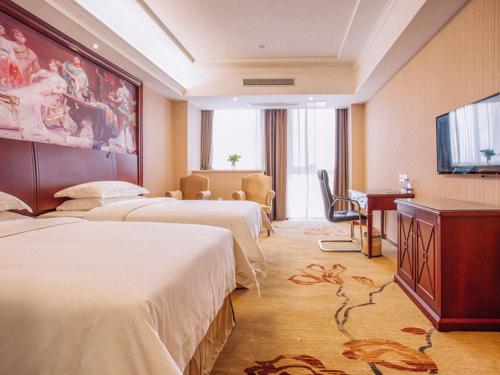 a hotel room with two beds and a flat screen tv at Vienna Hotel Jiangxi Yingtan International Glasses City in Yingtan