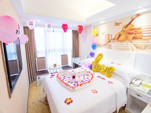 a room with a bed with a heart shaped cake on it at Vienna Hotel Guangxi Nanning International Convention and Exhibition Center in Nanning