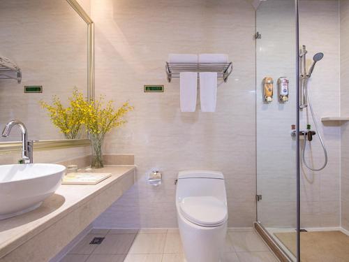 W łazience znajduje się prysznic, toaleta i umywalka. w obiekcie Vienna International Hotel Guangzhou Railway Station w Guangzhou