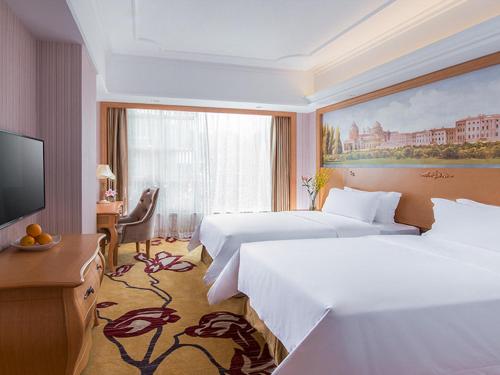 a hotel room with two beds and a flat screen tv at Vienna Hotel Shenzhen Unitown in Bao'an